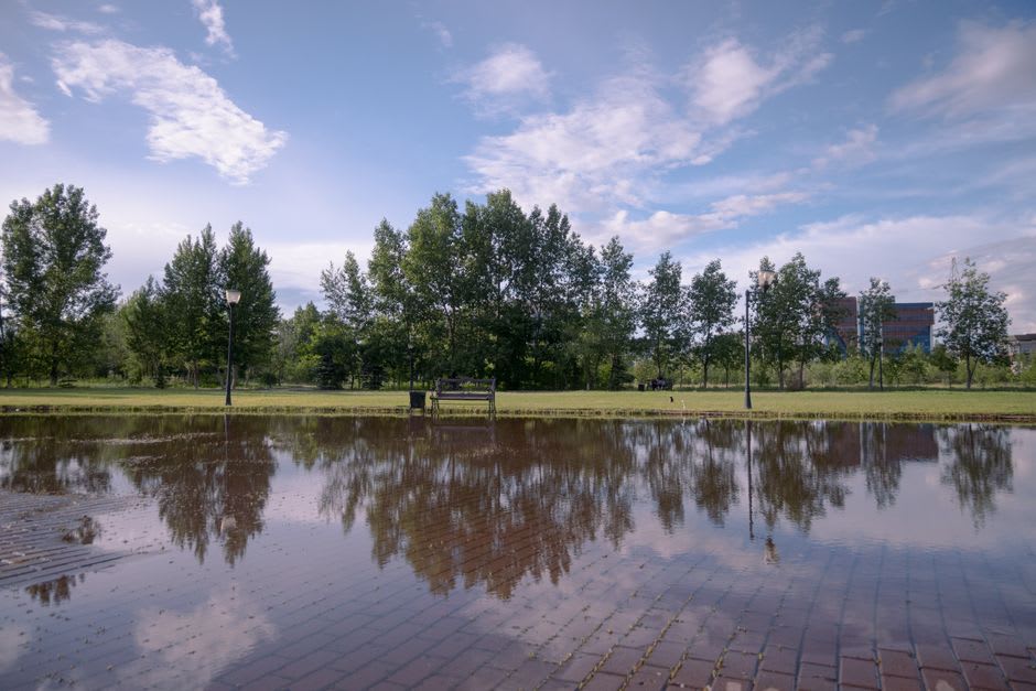 The Thio River running red-tinted after rain, mining hills visible in the background upstream