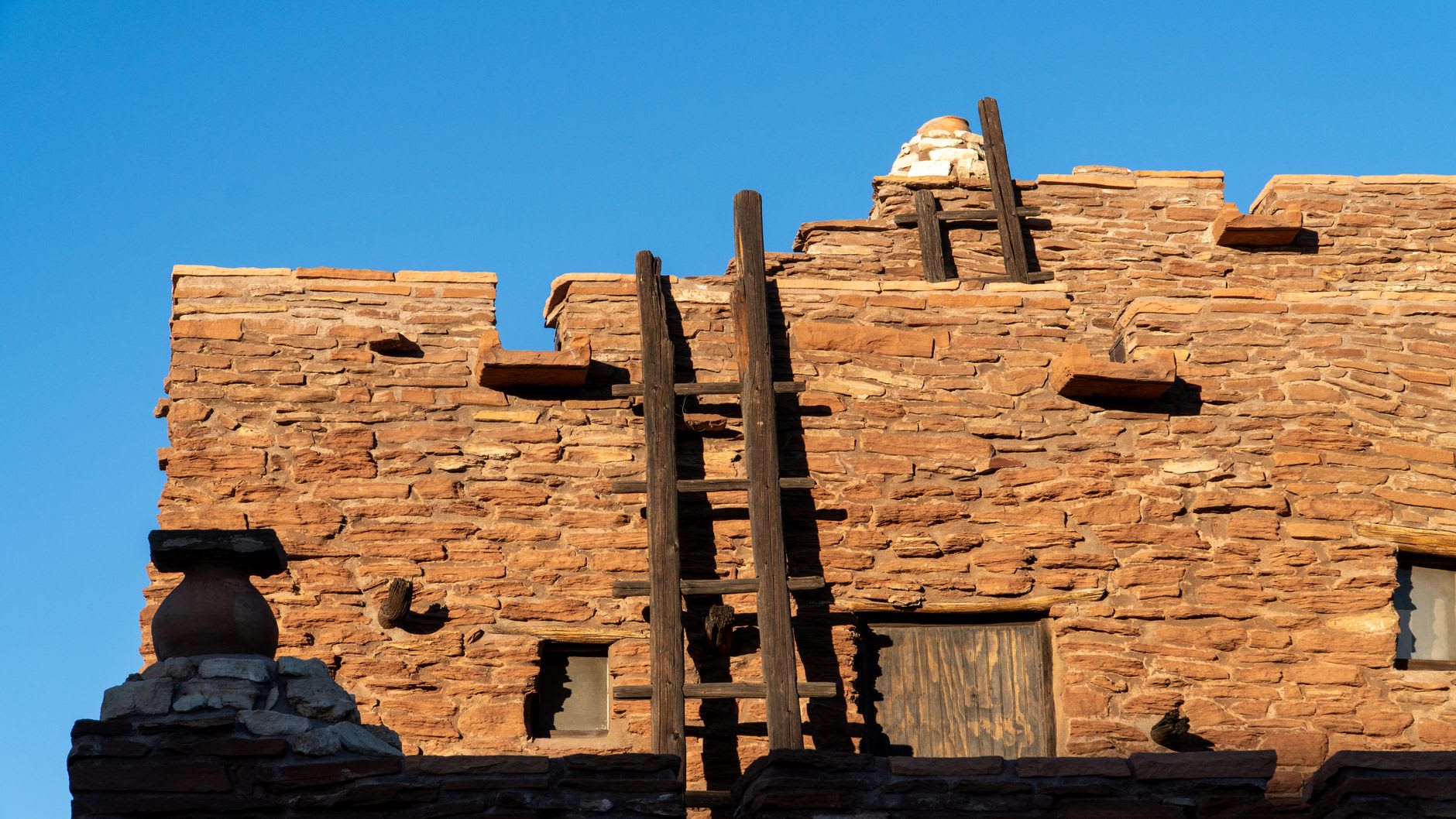 L'acequia de l'irrigation traversant le centre de Taos Pueblo, la maison du nord s'élevant derrière