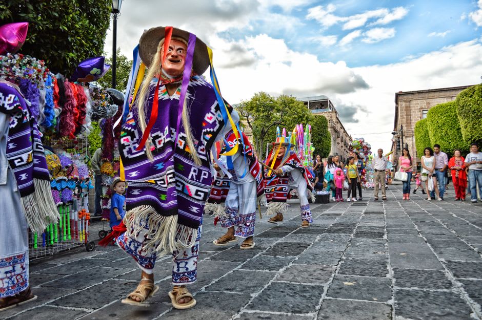 Des danseurs masqués en costumes coloniaux richement ornés se produisant dans les rues de Diriamba