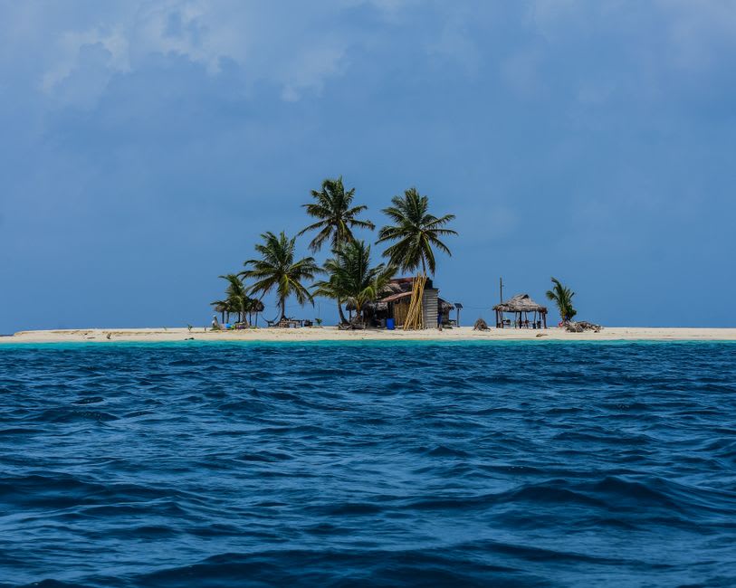 A small sandy caye with palm trees off the coast near Pearl Lagoon