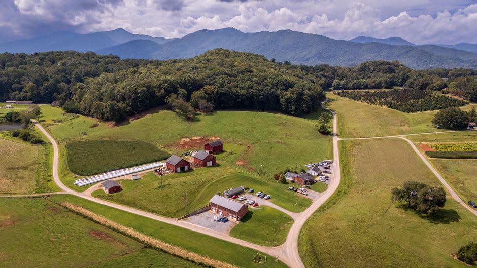 A dry-stone farmhouse on a ridge in the Peñas Blancas highlands with layered cloud-forest hills receding into the distance