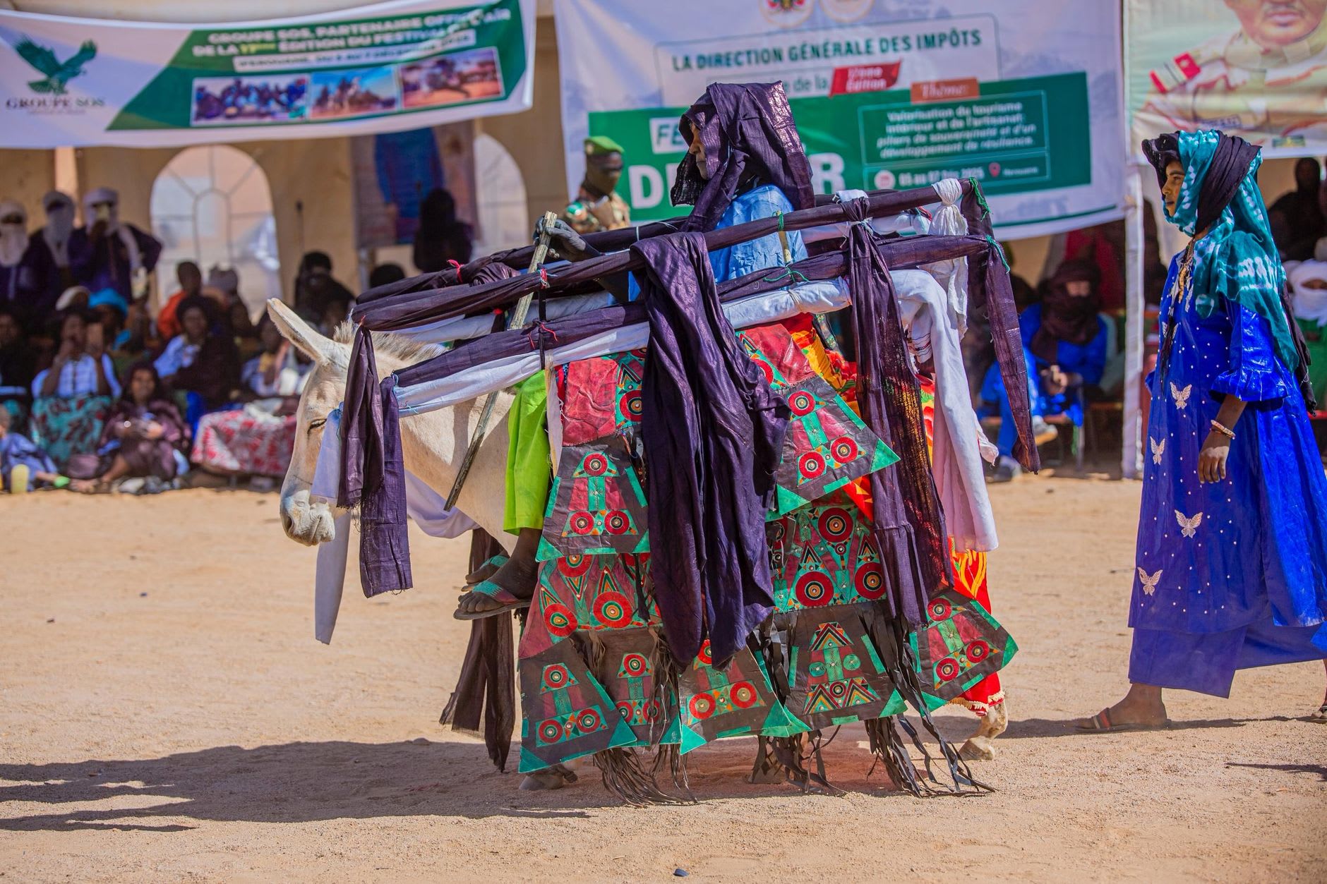Mujeres wodaabe con joyas de oro observando y juzgando la ceremonia de belleza Gerewol en la Cure Salée, con expresiones atentas y deliberadas