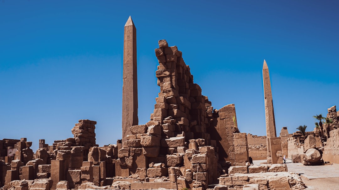 Sunrise light striking the colonnaded terraces of Deir el-Bahari with long shadows across the stone