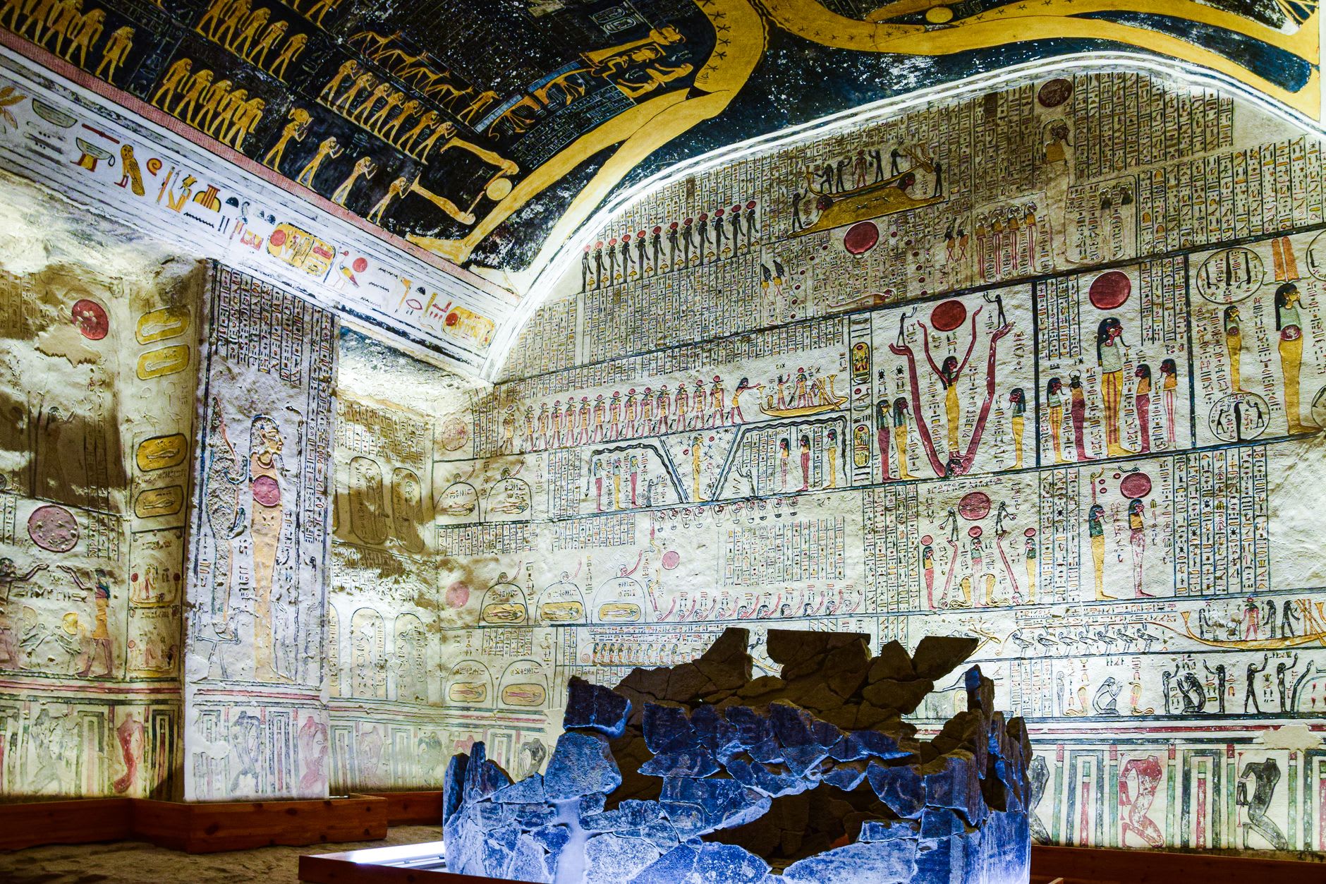 Wall paintings inside a royal tomb showing the pharaoh before Osiris, blues and ochres still vivid after three thousand years