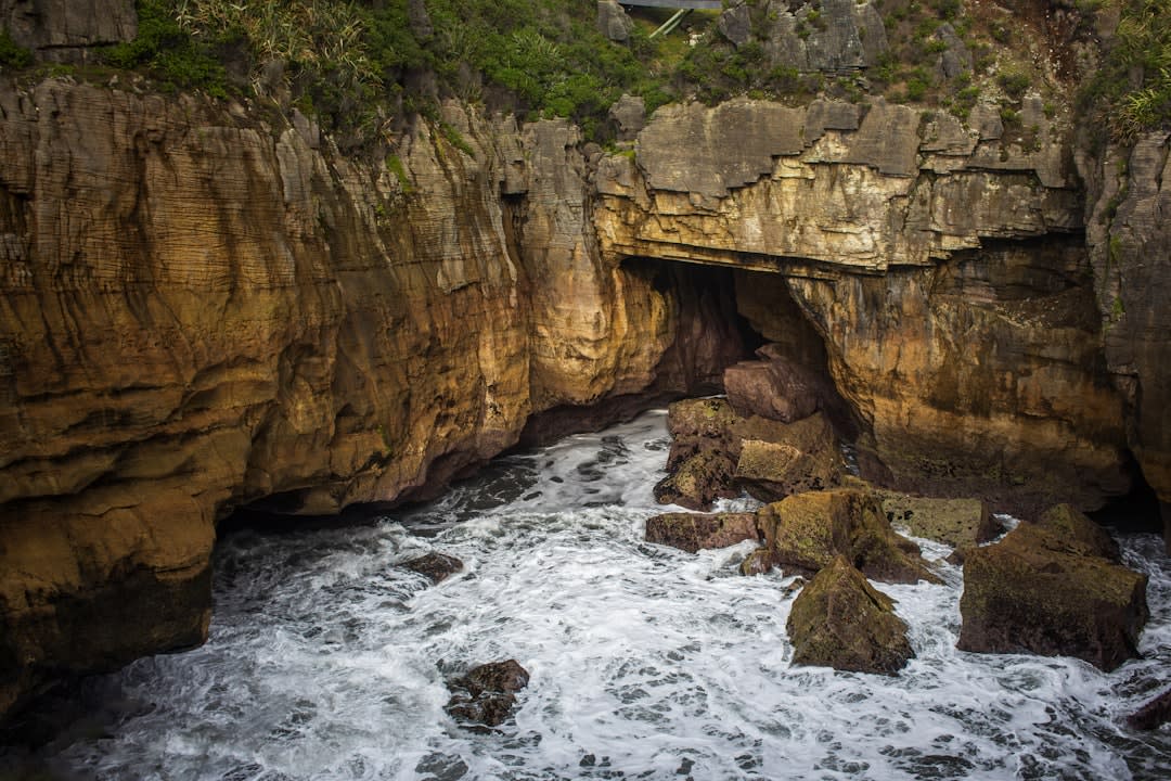 Sunlight filtering through the opening of Anapala Chasm onto the still water below