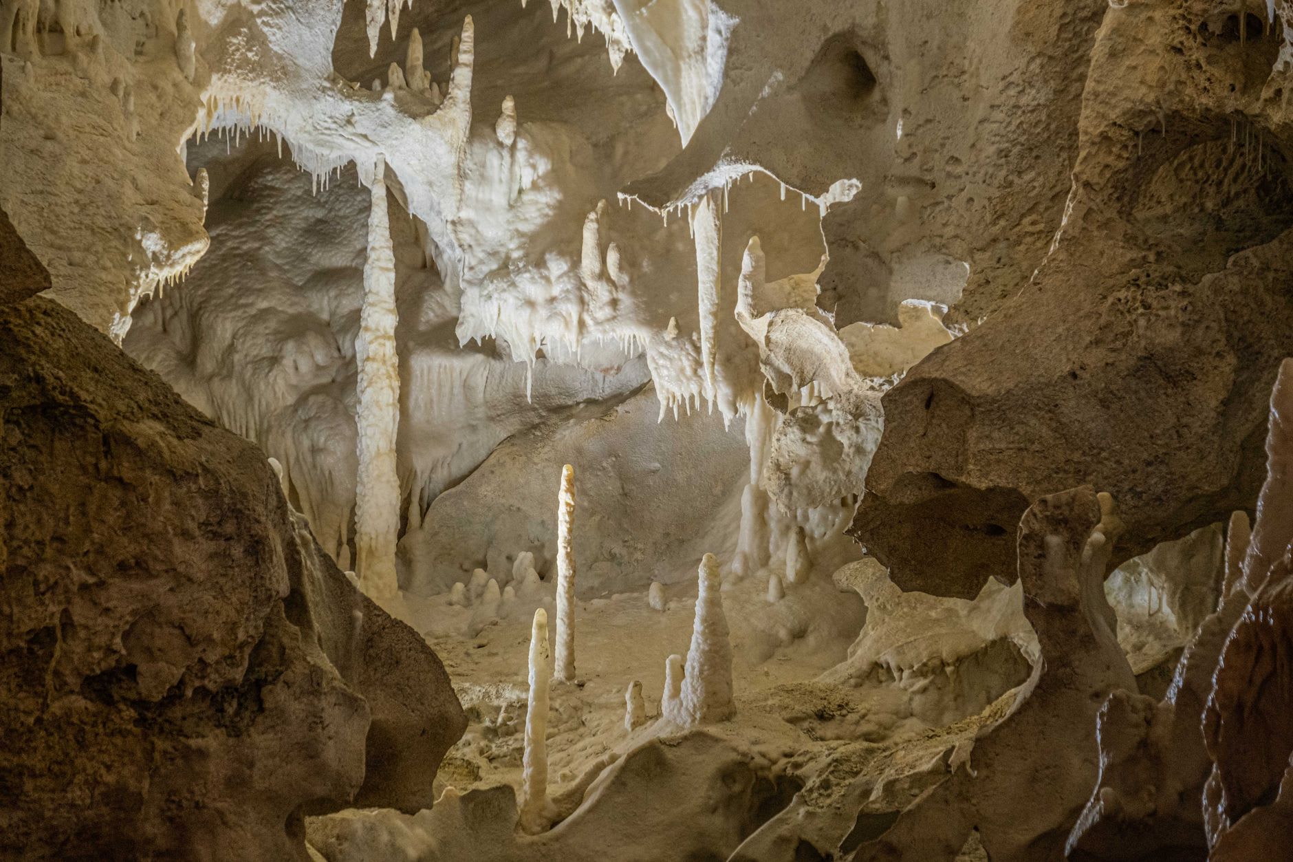 Le plafond de stalactites de la Grotte de Palaha au-dessus de la piscine turquoise, lumière entrant par la bouche de la grotte