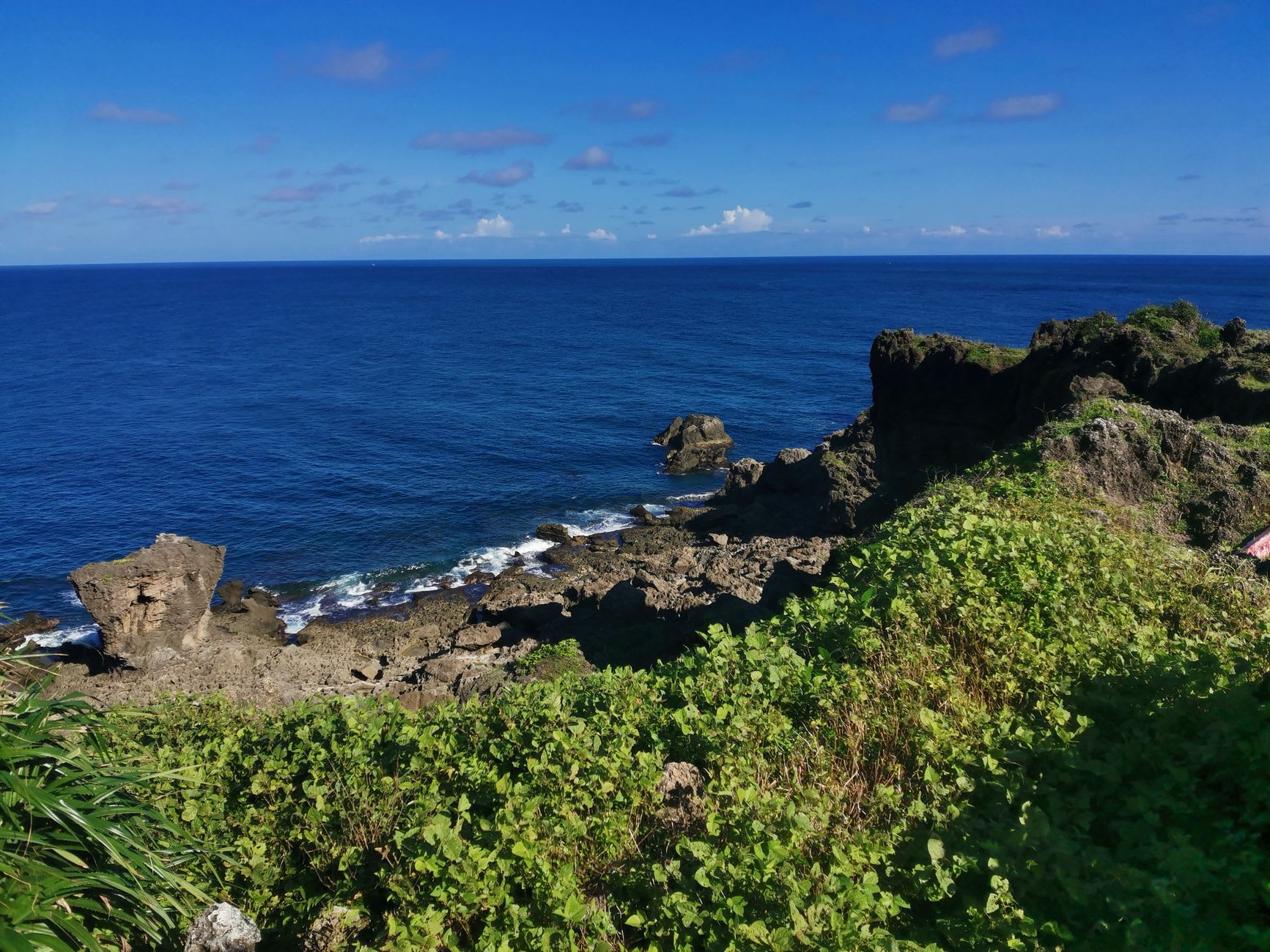 The dark sand and shallow reef at Tamakautoga, water in shades of turquoise and jade