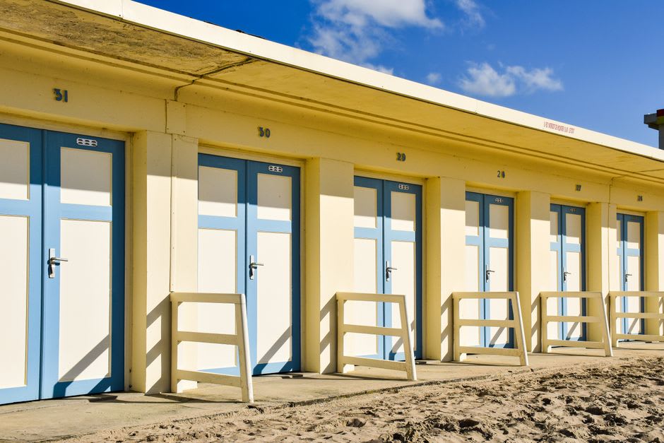 Striped beach cabins along Les Planches boardwalk bearing the names of film stars