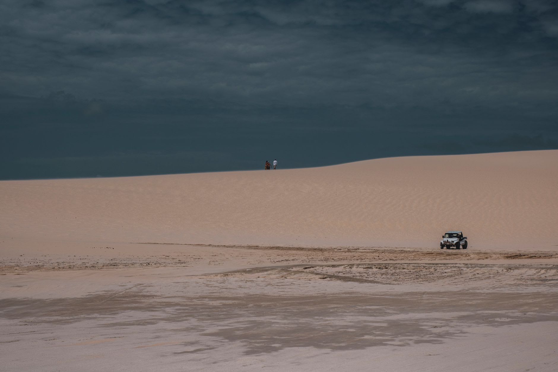 Un kitesurfista despegando de la laguna detrás de Jericoacoara, el viento llenando la cometa y el agua plana brillando con la fuerte luz de la tarde