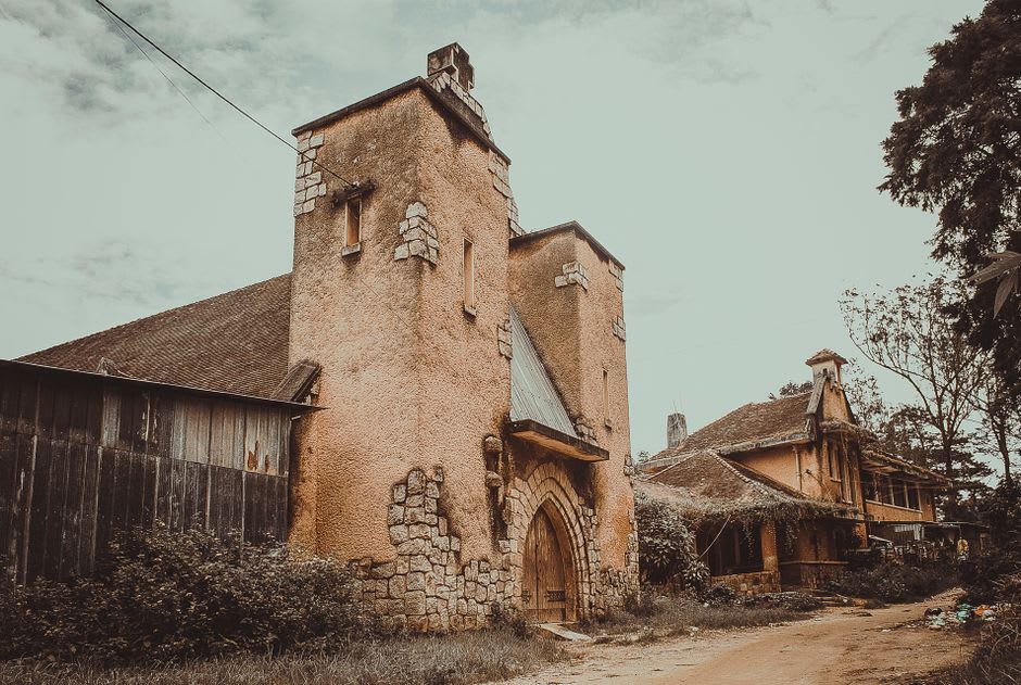 Ruined French colonial villa overgrown with vegetation on the slopes of Mau Son