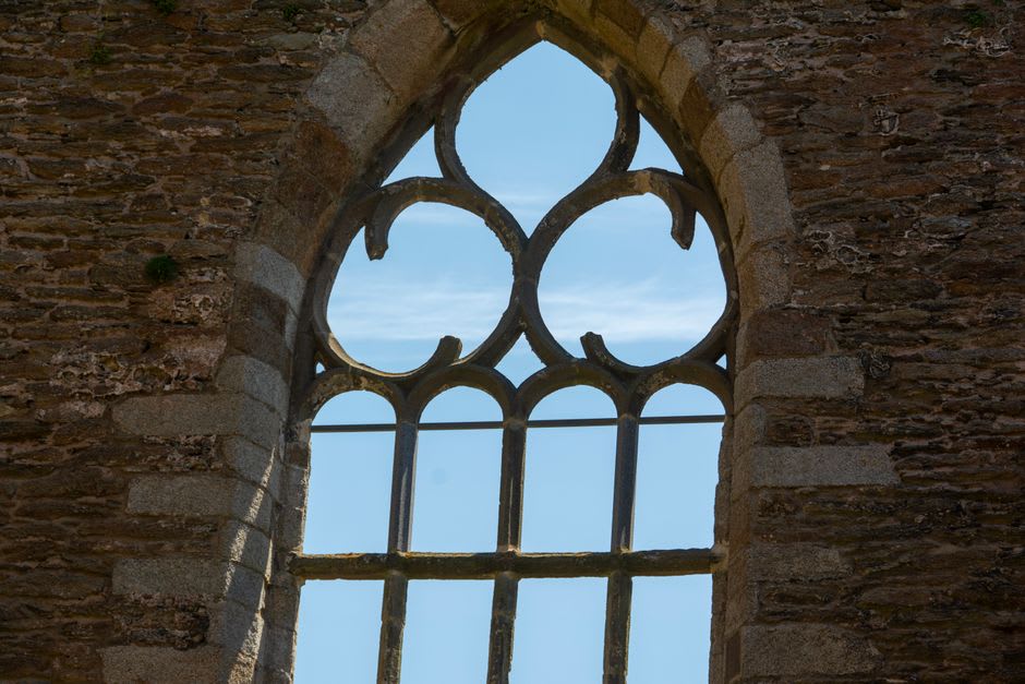 The ruined walls of Downhill House with empty window frames open to the sky
