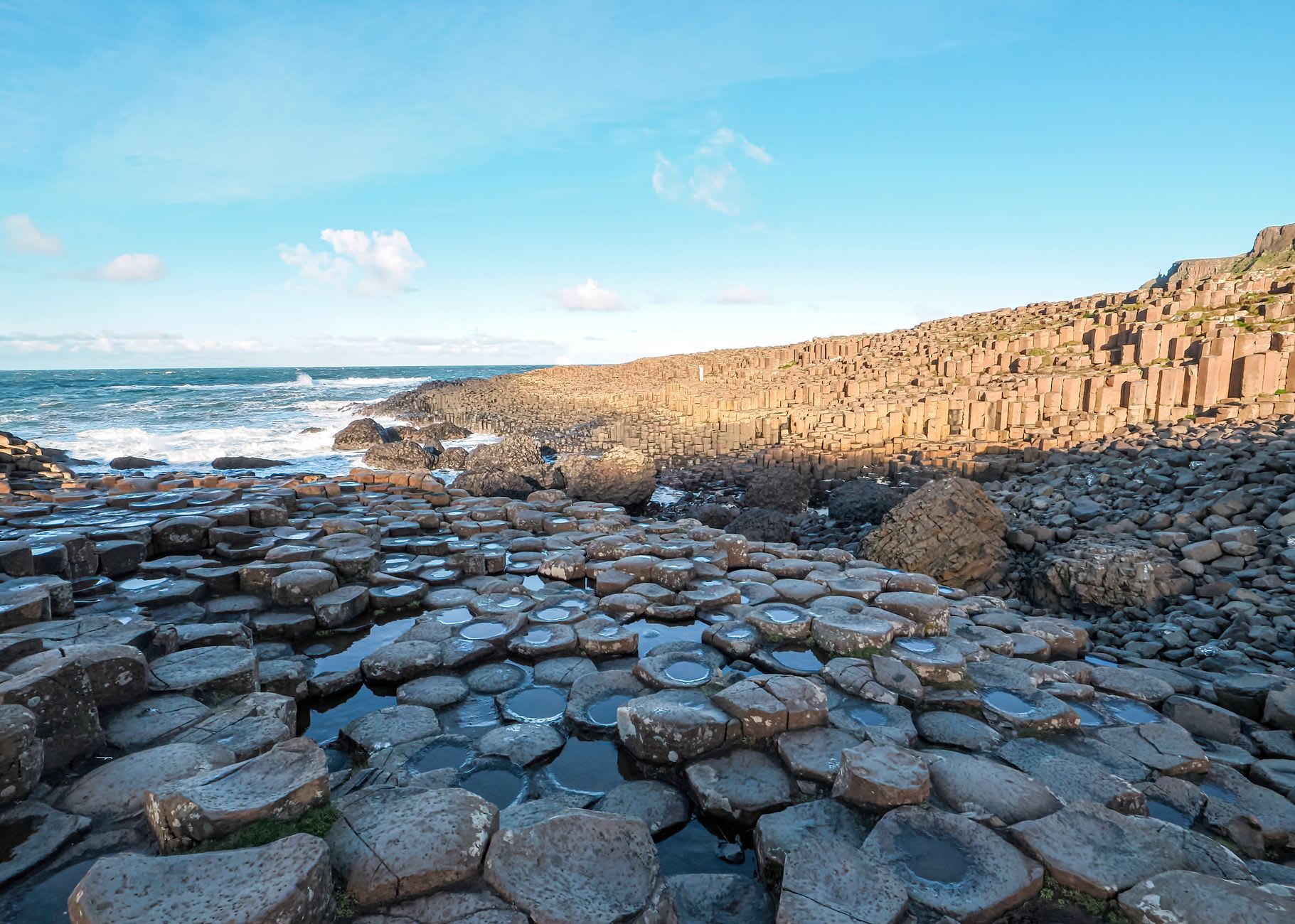 Close detail of the hexagonal basalt columns, their flat tops creating a perfect mosaic that extends toward the Atlantic