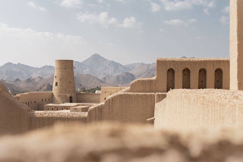 A traditional potter's wheel and unglazed terracotta bowls in the Bahla souq beneath the fort