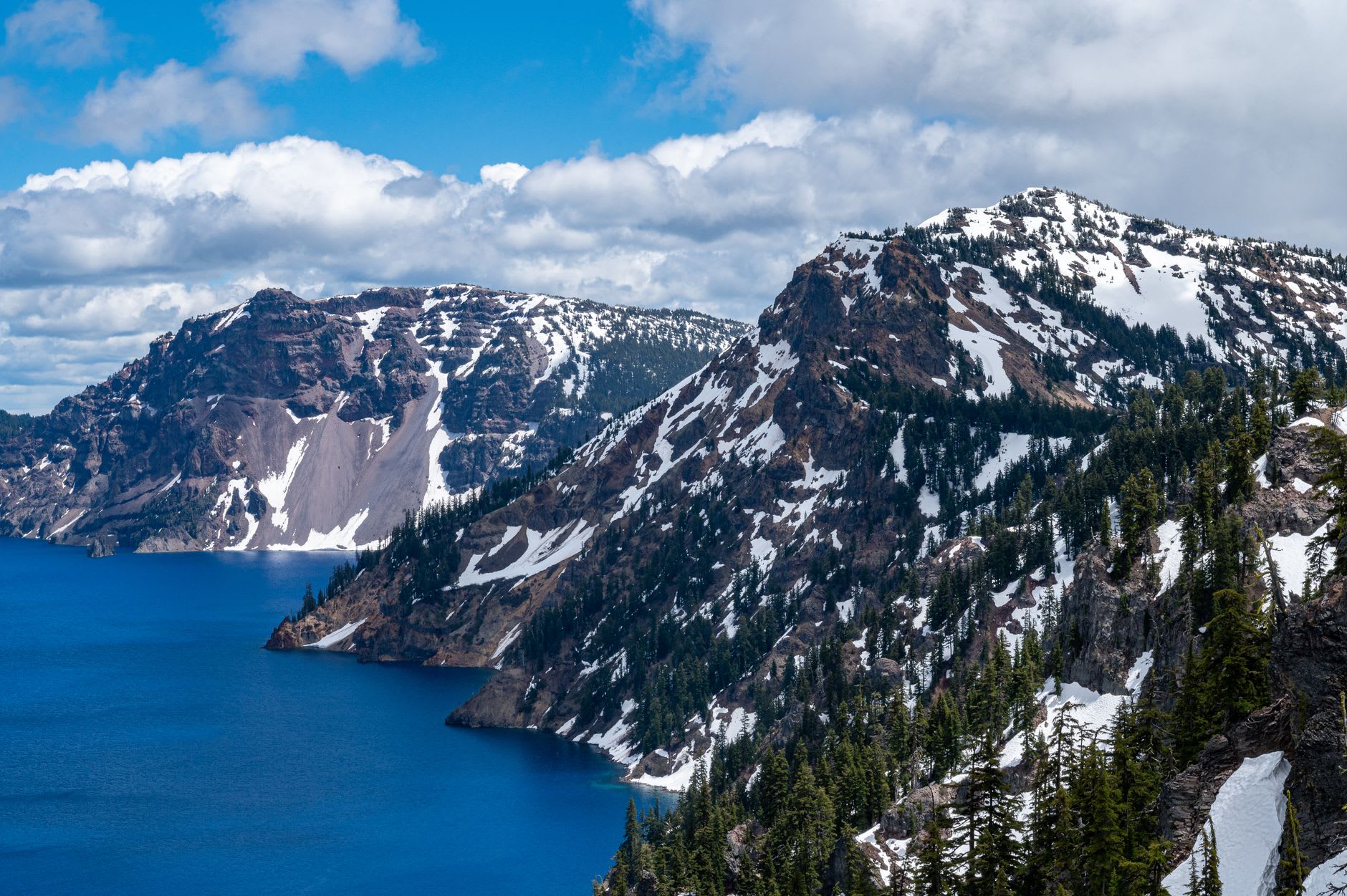 Wizard Island rising from the center of Crater Lake at golden hour, reflected in the still blue water