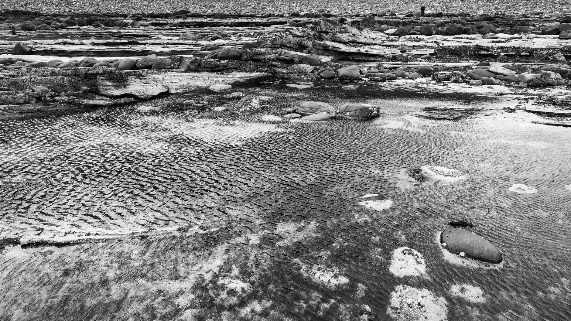 The Bay of Skaill behind Skara Brae, green waves breaking on the sand that once covered the Neolithic settlement