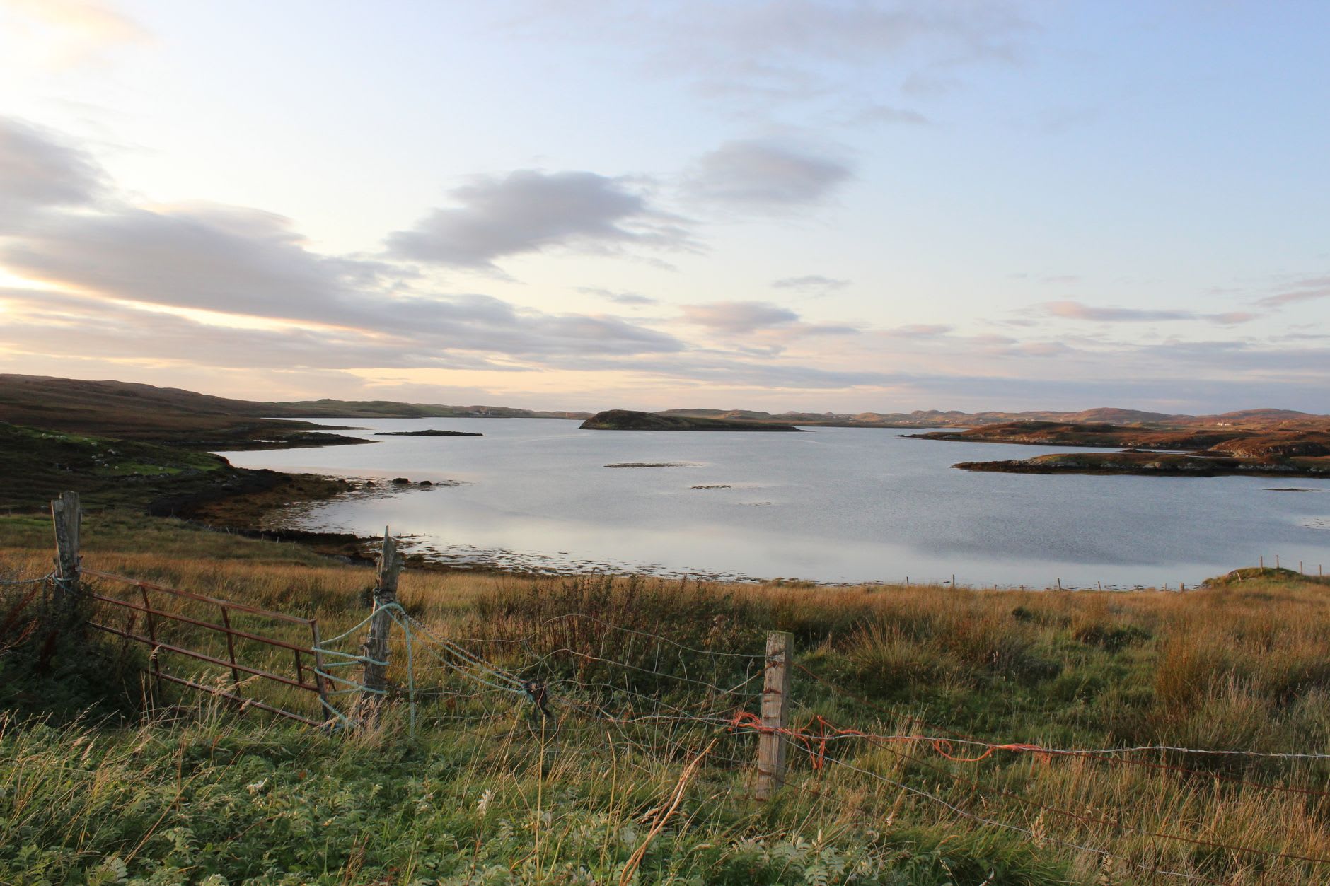Vue large des vasières de Luskentyre à marée basse avec de l'eau turquoise et du sable blanc sous un ciel plein du mouvement des nuages