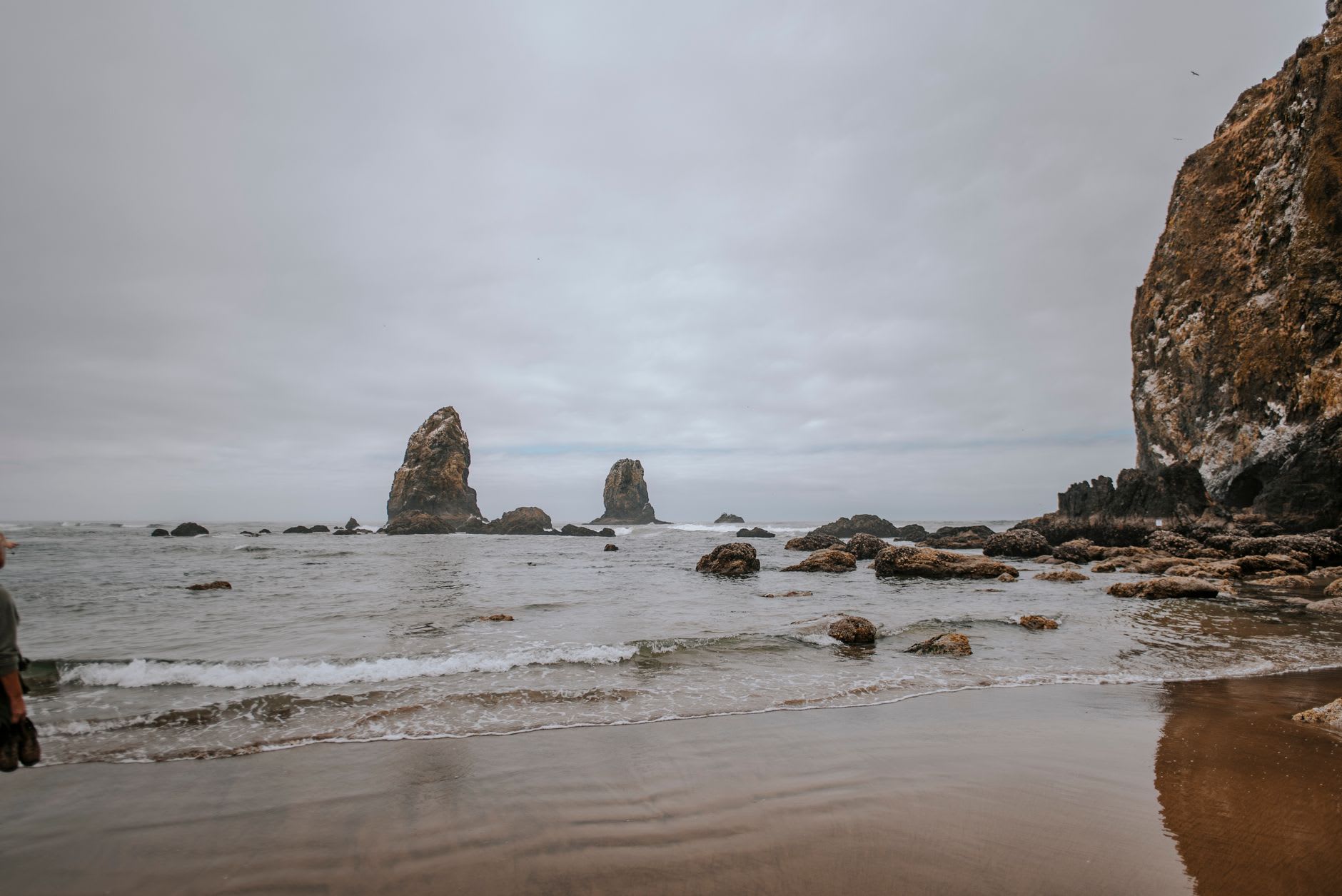 Vue vers le nord le long de Cannon Beach au crépuscule, le brouillard entrant du Pacifique, la ligne de ressac brillant dans la dernière lumière