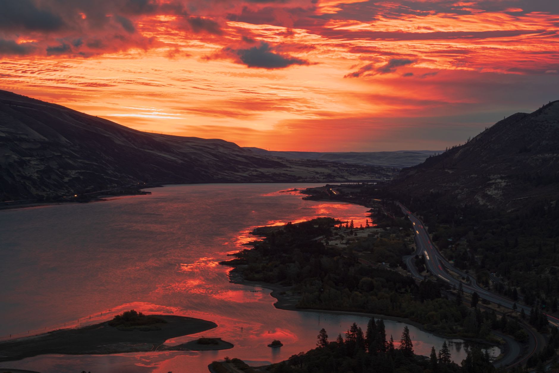 Windsurfers on the Columbia River at Hood River, bright sails against the basalt cliffs of the gorge