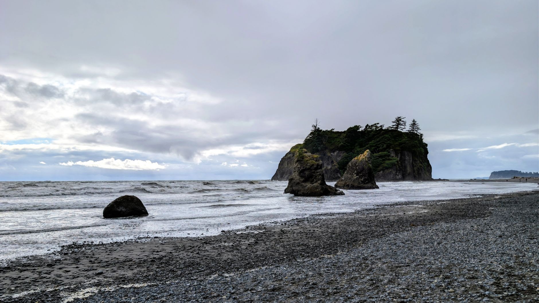 Plage sauvage jonchée de bois flotté à Ruby Beach, stacks marins émergeant du ressac gris du Pacifique