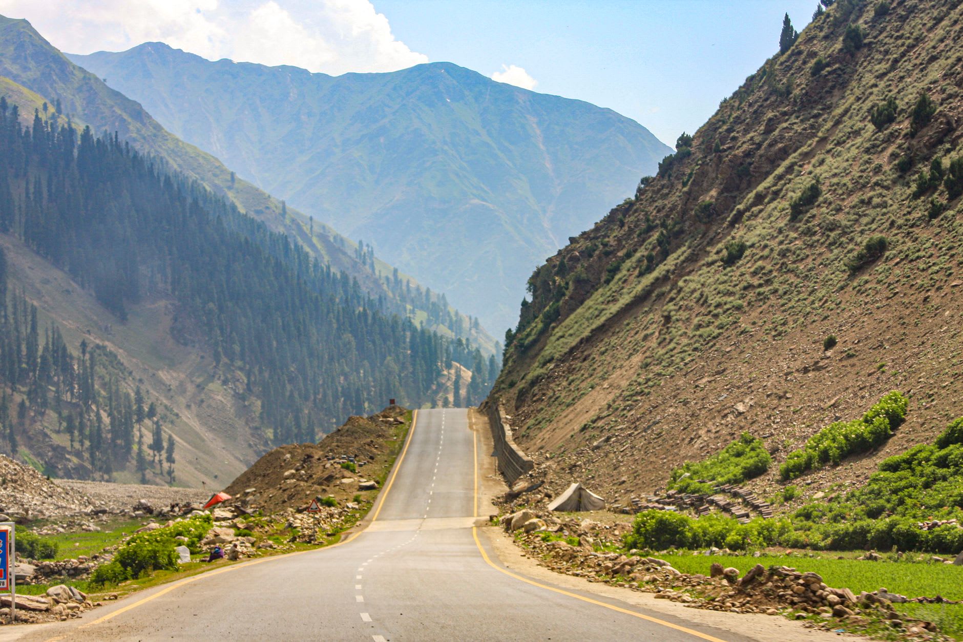 The Karakoram Highway at the Indus-Gilgit confluence, two rivers meeting in different colors below the highway bridge