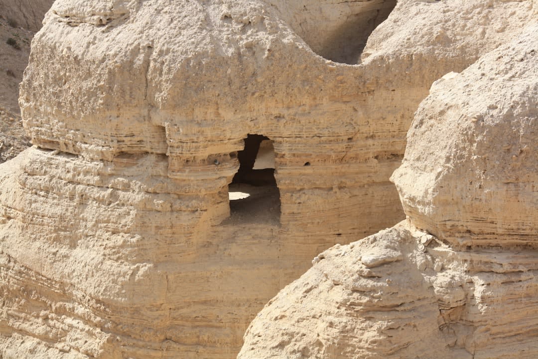 Les ruines du site de Qumrân avec les falaises criblées de grottes s'élevant à l'arrière-plan