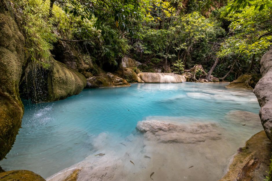 A clear jungle waterfall cascading into a rock pool inside Chagres National Park