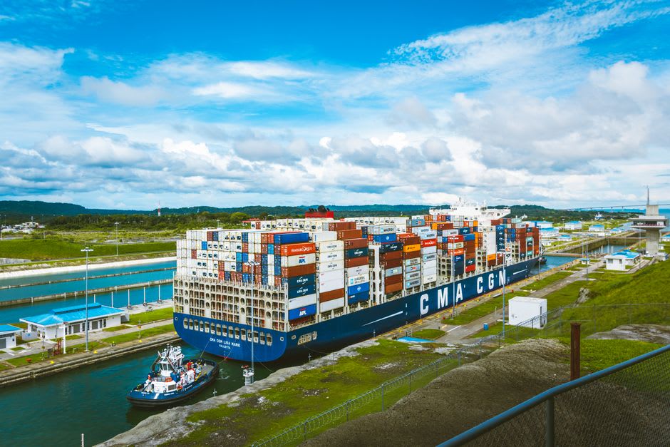 A container ship passing through a jungle-lined section of the Panama Canal near Gamboa, seen from an elevated observation tower