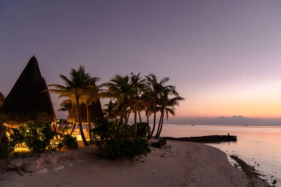 Palm-thatched beach bars and yoga platforms set back from the sand at Playa Venao at sunset