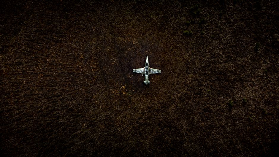 La zone de l'ancienne piste d'atterrissage de guerre près de l'aéroport de Lae, herbe envahissante et horizon bas sous un lourd ciel tropical nuageux