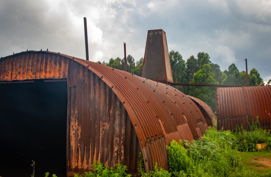 Rusting WWII-era Quonset hut frames near Seeadler Harbour on Manus Island, jungle vegetation growing through the metal structures
