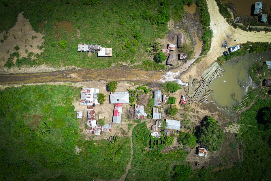 L'établissement isolé de Bahía Negra vu depuis le fleuve Paraguay au crépuscule, bâtiments en bois le long de la rive marécageuse