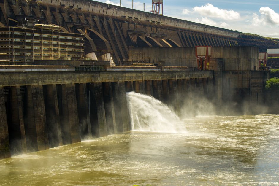 Mist rising from the Itaipu Dam spillway near Ciudad del Este, water thundering down the concrete gorge