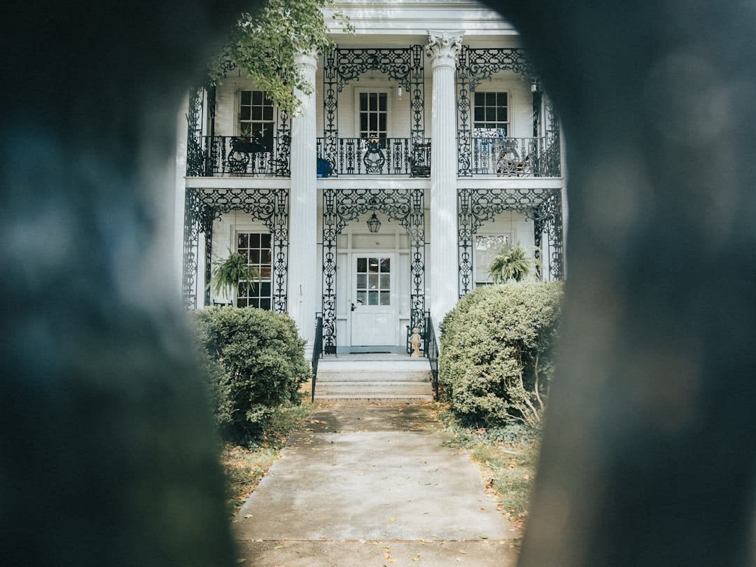 A weathered ironwork balcony on an abandoned mansion in Concepcion, vines climbing the columns below