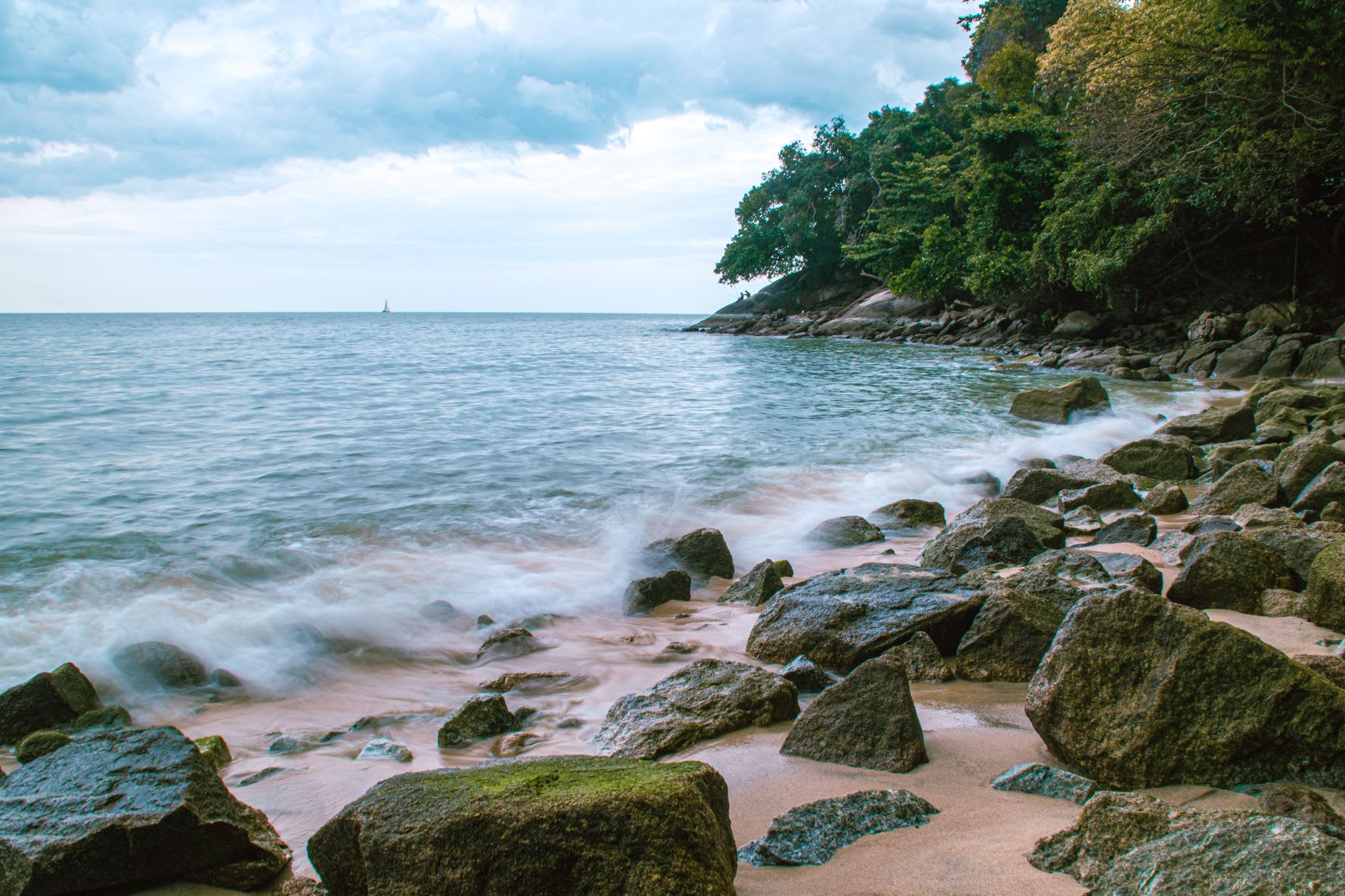 A quiet fishing kampung on the southwest coast of Penang, boats beached at low tide with coconut palms behind