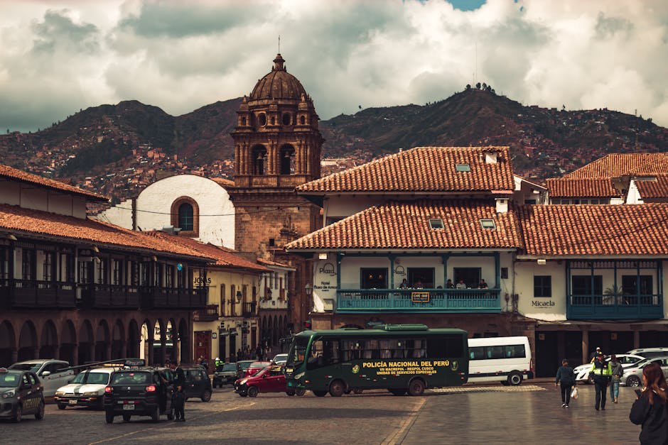 Panoramic view of Cusco's terracotta rooftops against green Andean hills