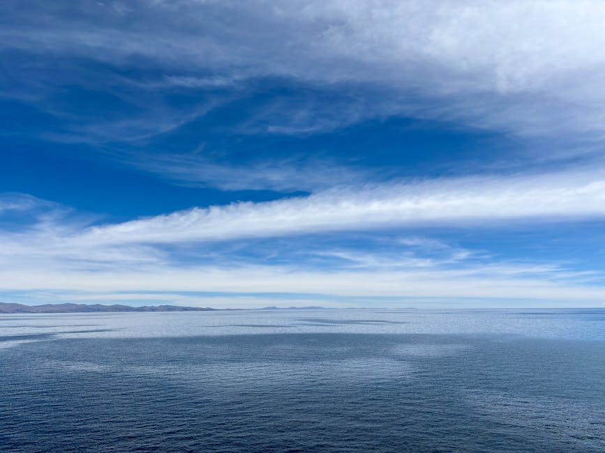 Deep blue waters of a high-altitude lake stretching to distant mountains