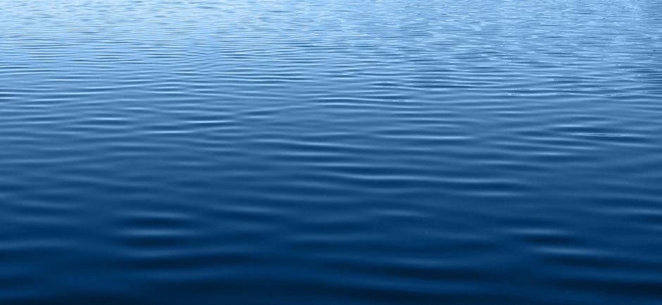Sunset colours reflected on calm lake waters with mountain silhouettes