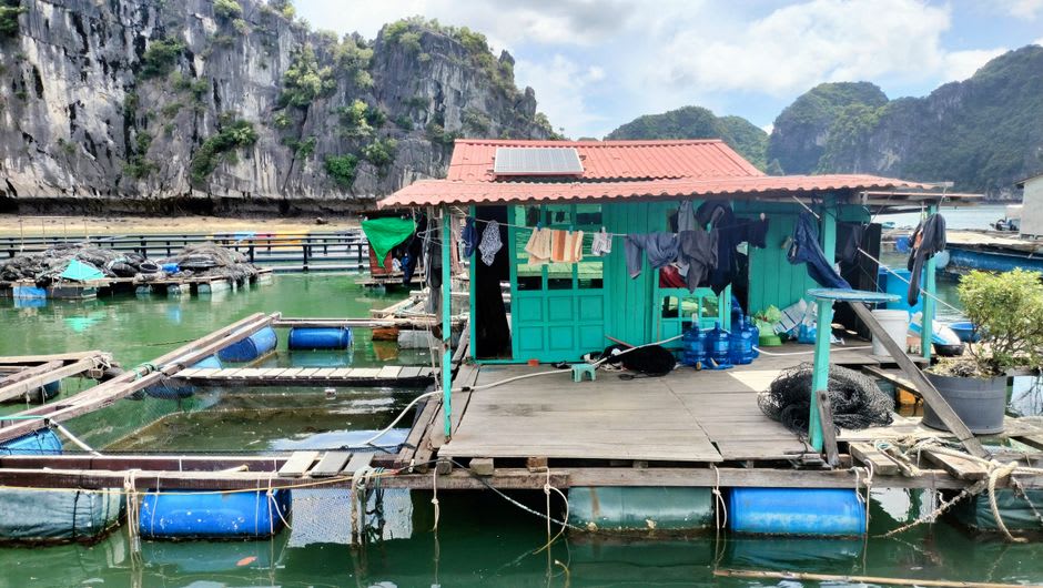 Stilt house on the tidal estuary with fishing nets drying in the afternoon sun
