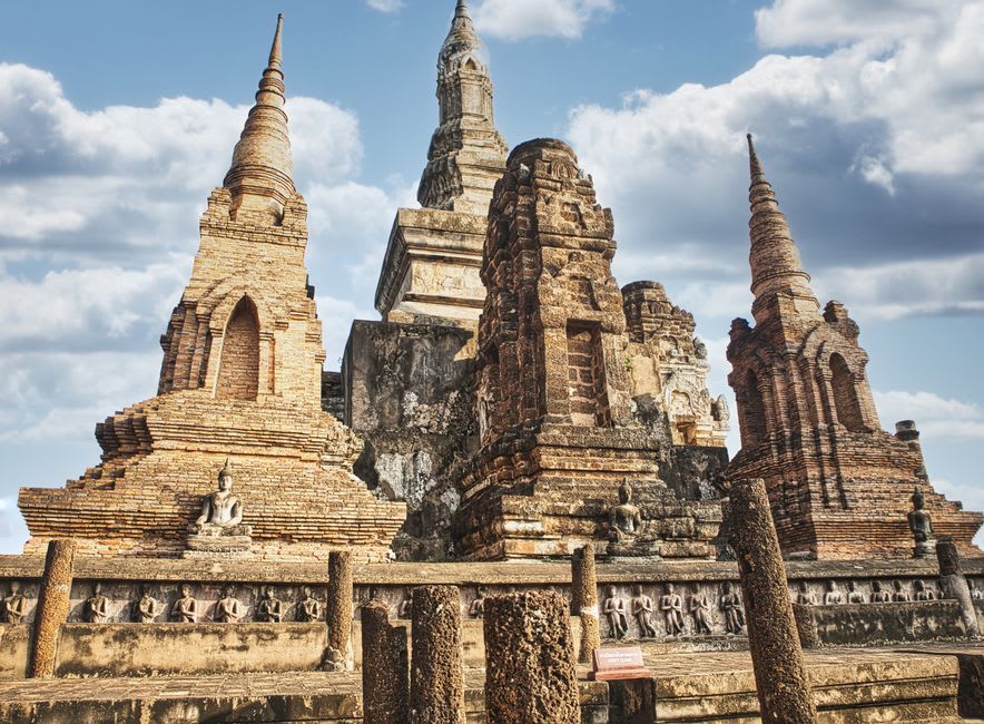 The weathered brick stupa of That Foun standing alone in the old town of Muang Khoun