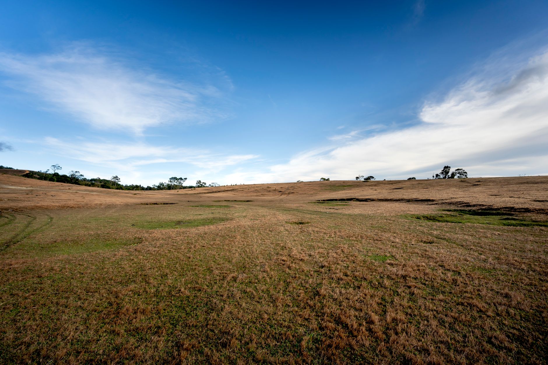 Stone jars scattered across the upper hillside of Site 3, with the plateau and distant hills stretching to the horizon