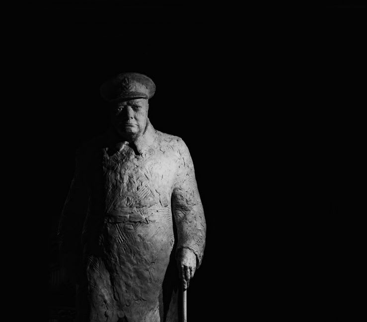 Bronze statue of Winston Churchill painting at his easel overlooking Câmara de Lobos harbor