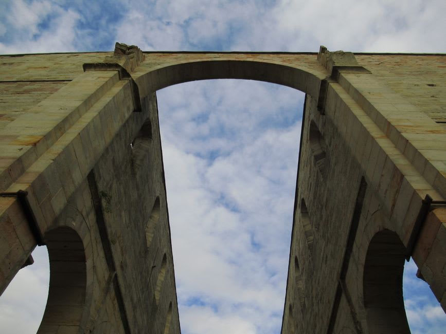 The multi-tiered stone arches of the Amoreira Aqueduct stretching across the plain toward Elvas