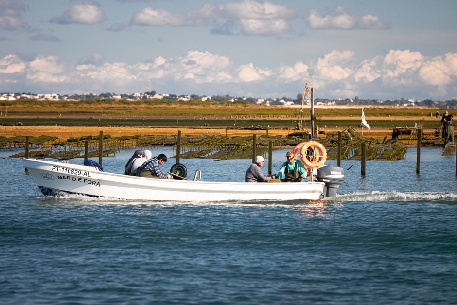 Traditional wooden boat crossing the Ria Formosa lagoon channels toward the barrier islands near Faro