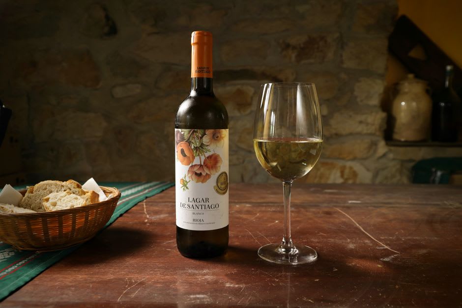 Glass of golden Moscatel wine served alongside a warm round loaf of traditional Favaios bread