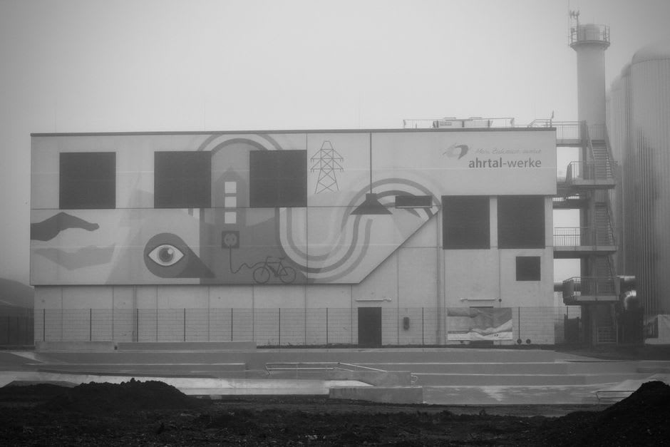 Urban street art mural on the side of a converted factory building in Fundão