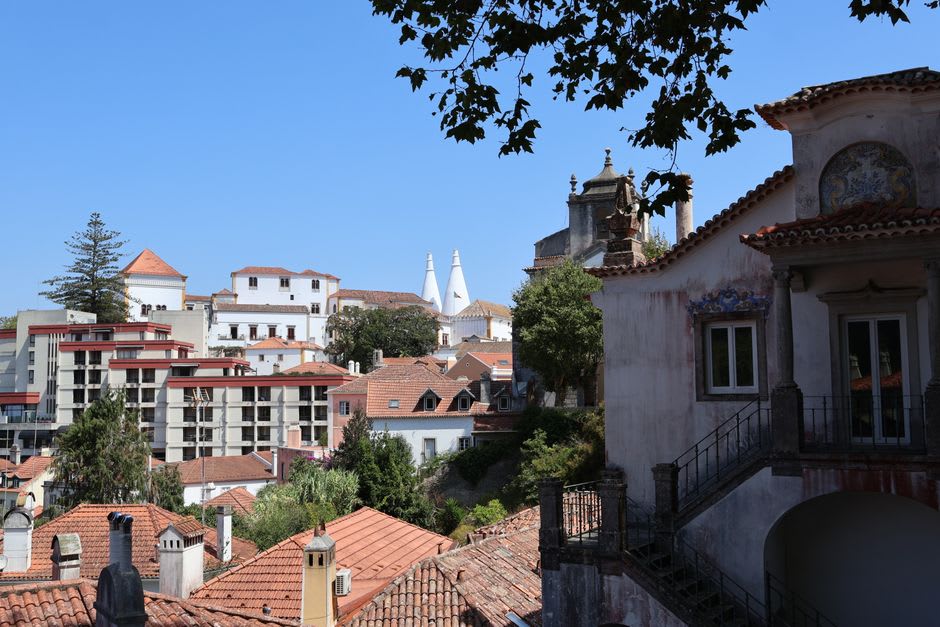 Faded pastel spa buildings and a stone fountain in the quiet thermal village of Caldas de Monchique surrounded by forest