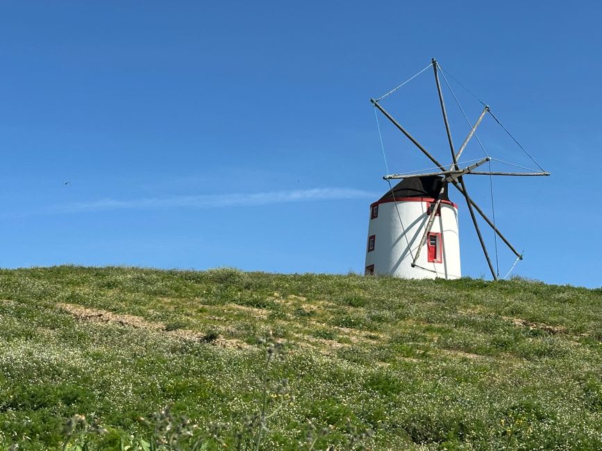 Traditional whitewashed windmill on the hilltop above Odeceixe village with the river valley below