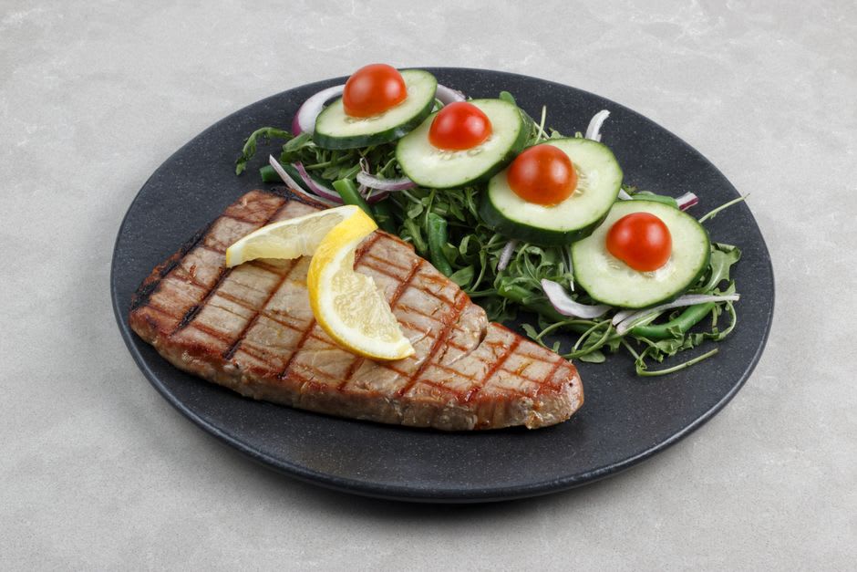 Grilled swordfish steak served with boiled potatoes at a Sesimbra harborside restaurant