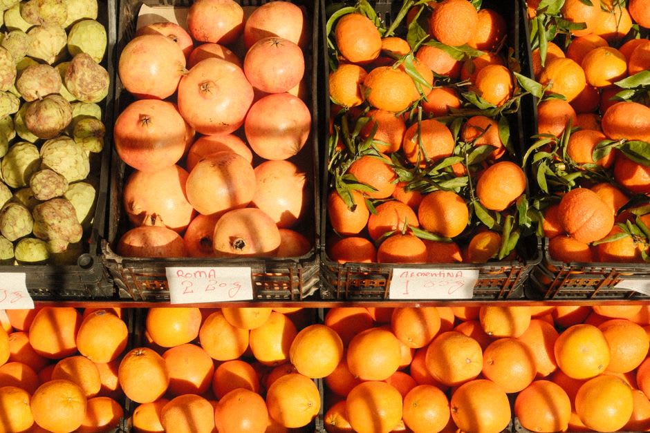 Roadside stand piled with fresh oranges just outside Silves, orange groves visible in the background