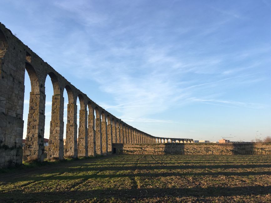 Row of stone arches of the historic aqueduct leading toward the Santa Clara convent in Vila do Conde